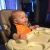 A baby sits in a highchair, looking off camera for more food.